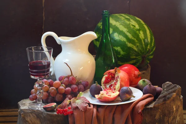 Κρασί, σταφύλια, ένα ρόδι, ένα σύκο, καρπούζι και ένα λευκό ju — Φωτογραφία Αρχείου