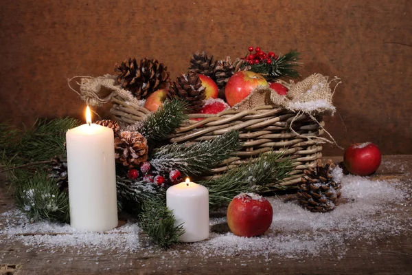 Appels en kegels in een Chalinolobus mand, kaarsen en een pine branch — Stockfoto