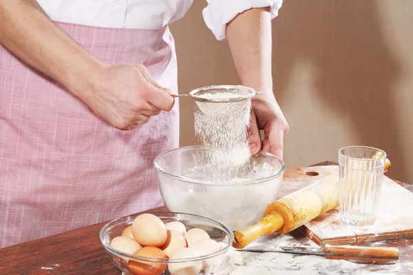 Preparation of the test for pelmeni, man 's the hand holds a stra — стоковое фото