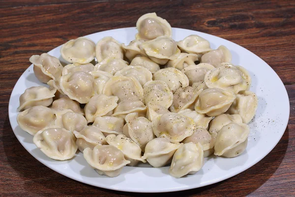 Pelmeni prêt soumis avec le beurre, parsemé de peppe moulu — Photo