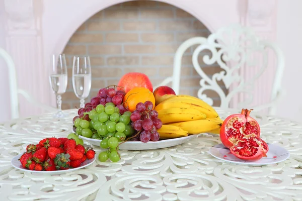 Vindruvor, bananer, ett granatäpple, en apelsin och äpplen och halm — Stockfoto