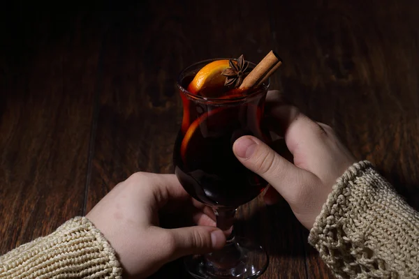 Man's hands hold a glass with mulled wine, mulled wine with an o — Stock Photo, Image