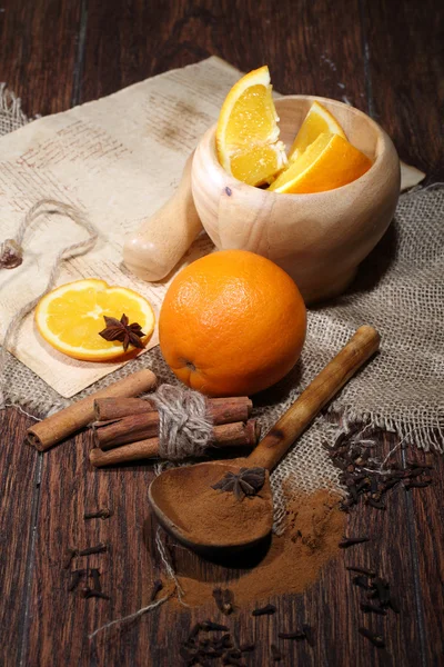 Naranja, canela, anís, clavel y mortero de madera — Foto de Stock