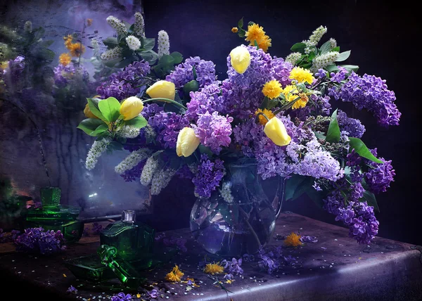 Lila en tulpen in een transparante kruik — Stockfoto
