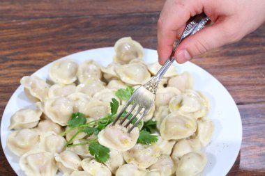 Üzerine tutturulmuş bir fiş elini tutan mantı