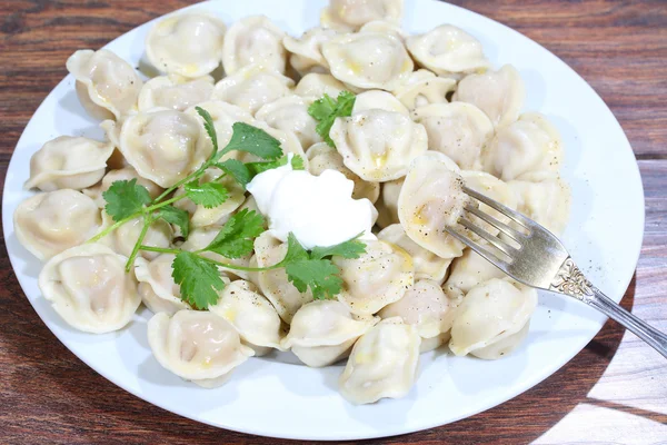 Pelmeni com creme de leite, a manteiga moída por pimenta e p fresco — Fotografia de Stock