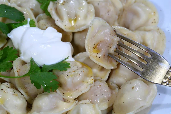 Pelmeni con crema agria, la mantequilla molida por pimienta y fresca p —  Fotos de Stock