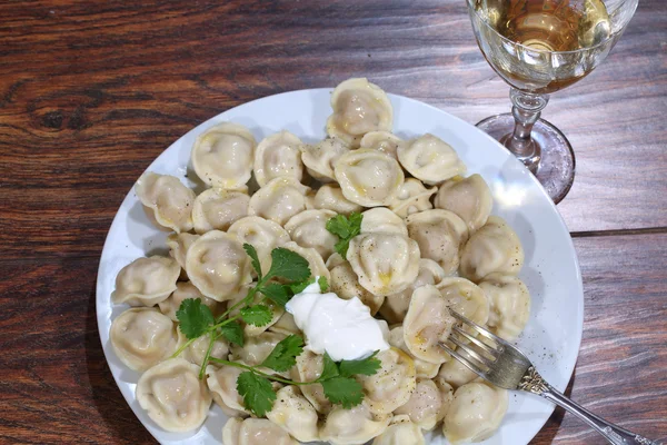 Vin et pelmeni dans une assiette — Photo