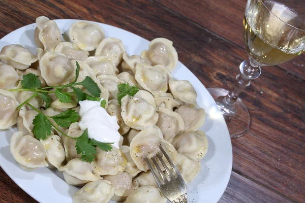 Pelmeni met zure room en witte wijn in een transparant glas — Stockfoto