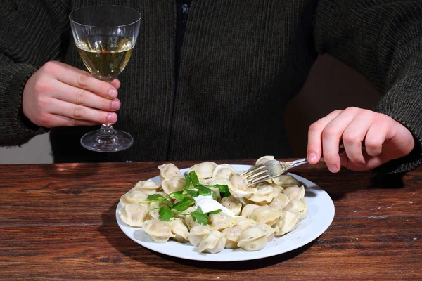 Wine glass in man's hands and pelmeni — Stock Photo, Image