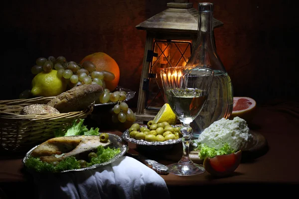 Salmone, vino, olive, formaggio, uva e una piccola lampada — Foto Stock