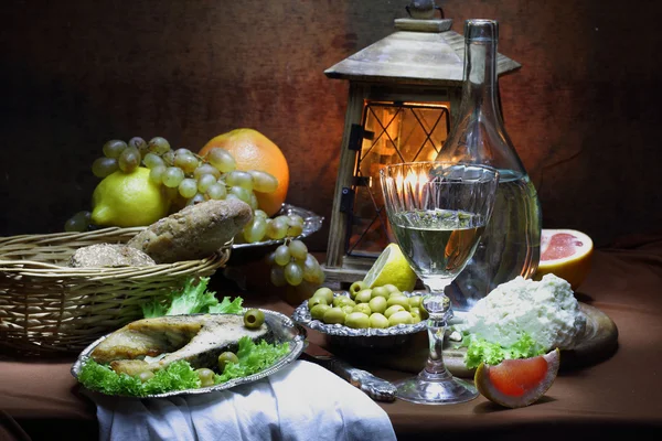 Salmon, wine, olives, cheese, grapes and a small lamp — Stock Photo, Image