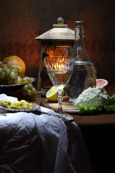 Vinho, azeitonas, queijo, uvas e uma pequena lâmpada — Fotografia de Stock