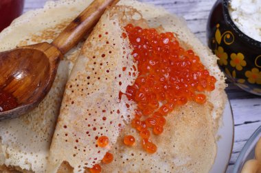 Kırmızı havyar ve bir tahta kaşık ile Pancakes