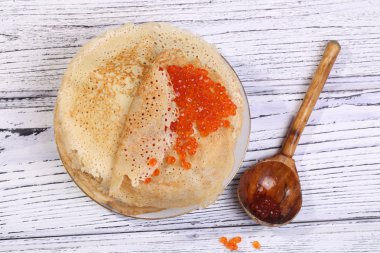 Kırmızı havyar ve bir tahta kaşık ile Pancakes