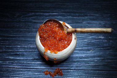 Ahşap kase ve bir tahta kaşık kırmızı havyar