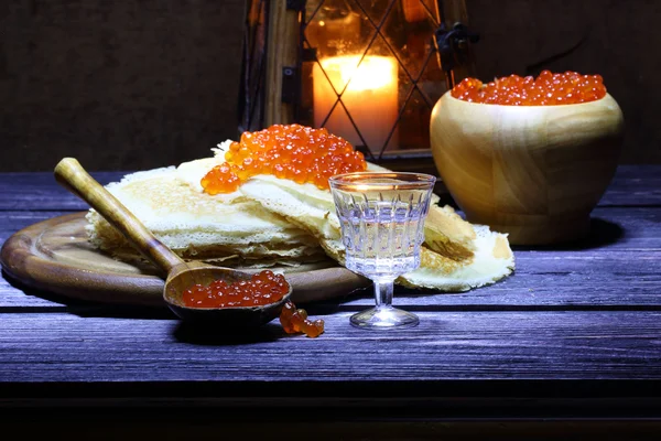 Pannenkoeken met rode kaviaar en een wijn-glas wodka en een oude la — Stockfoto