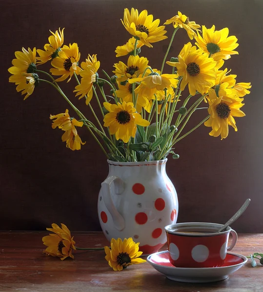 Tè in una bella tazza e un mazzo di camomille gialle — Foto Stock