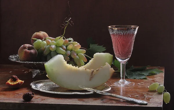 Vin accompagné d'un melon, de pêches et de raisins — Photo