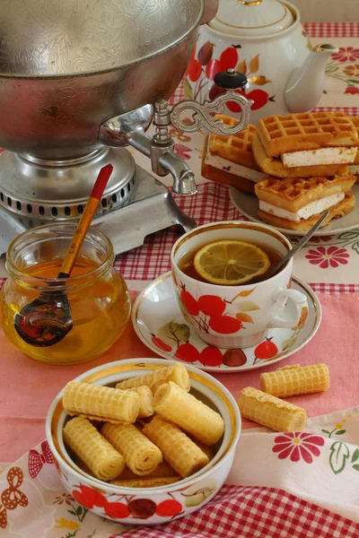 Thee uit een Samowar, met een citroen, honing, gebak en wafeltjes — Stockfoto
