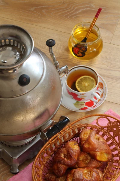 Té de un samovar, con limón, miel y rollos —  Fotos de Stock