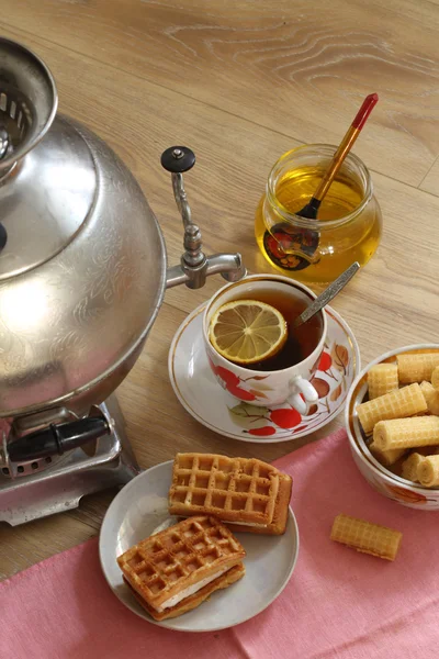 Herbata z samowar, z cytryny, miód, ciasta i wafelki — Zdjęcie stockowe