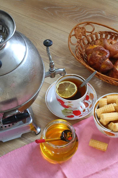 Té de un samovar, con limón, miel, panecillos y obleas —  Fotos de Stock