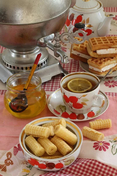 Té de un samovar, con limón, miel, pasteles y obleas —  Fotos de Stock