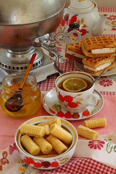 Té de un samovar, con limón, miel, pasteles y obleas —  Fotos de Stock