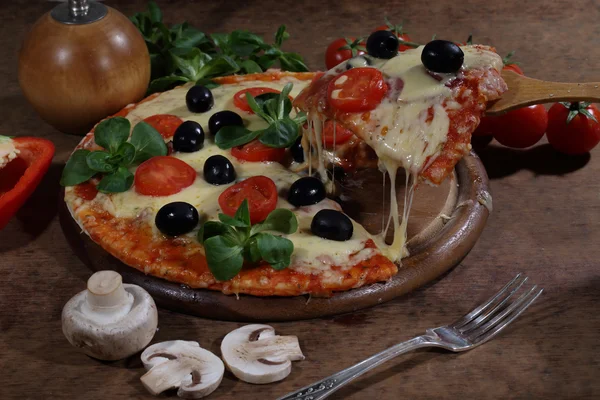 Pizza kus výtah na dřevěnou lopatku — Stock fotografie