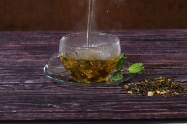 Şeffaf bir fincan çay akar