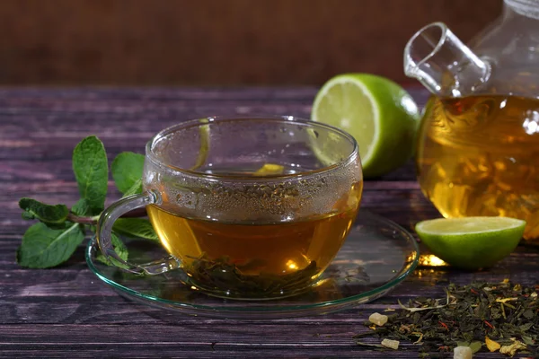 Thee in een glas theepot en een transparante cup met kalk en mint o — Stockfoto