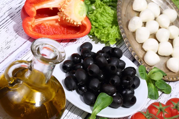 Olive, pomodori, pepe, una mozzarella e ruccola — Foto Stock