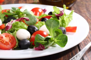 Bir Mozzarella peyniri, domates, zeytin, salata salata 