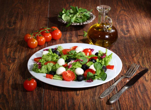 Салат с моцареллой, помидорами, оливками, салатом — стоковое фото