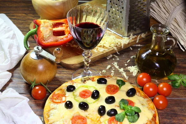 Červené víno v průhledného skla a pizza — Stock fotografie