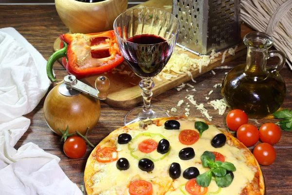 Červené víno v průhledného skla a pizza — Stock fotografie