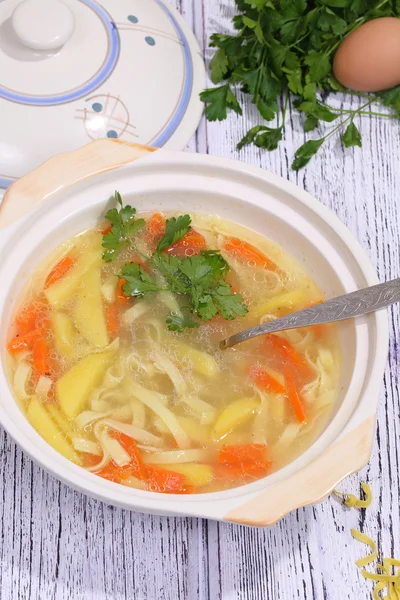 Chicken soup with egg and noodles submitted to a soup tureen — Stock Photo, Image