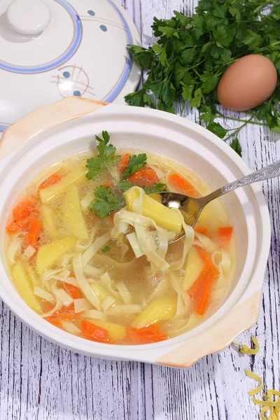 Chicken soup with noodles scoop from a soup tureen a spoon — Stock Photo, Image