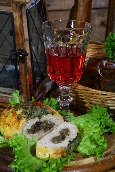 Wine in a glass and minced roll hens with a stuffing from mushro — Stock Photo, Image