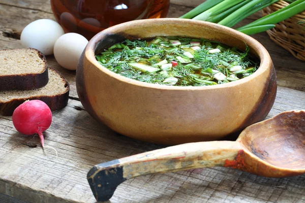 Okroshka with kvass in a wooden bowl and a wooden spoon — Stock Photo, Image