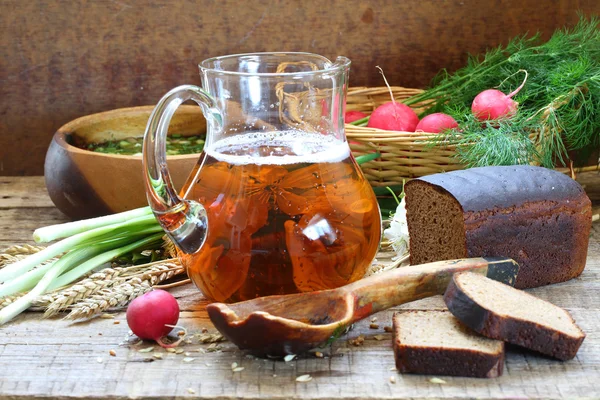 Jug with kvass, rye bread and okroshka in a wooden bowl — Stock Photo, Image