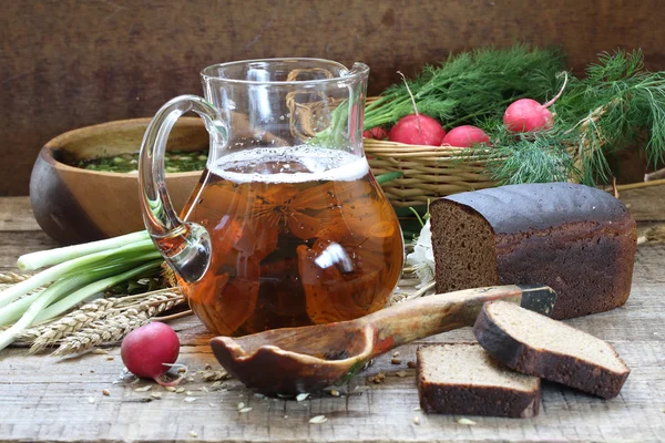 Caraffa con kvass, pane di segale e verdi con un ravanello di giardino in una b — Foto Stock