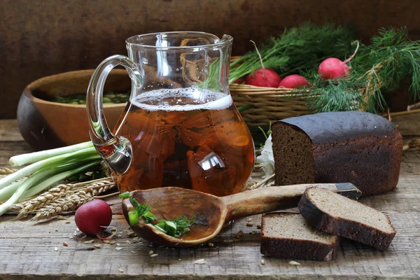 Caraffa con pane di segale e kvass su un tavolo di legno — Foto Stock