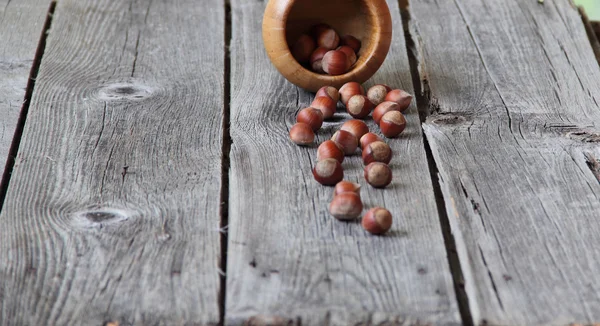 Wood nut in a wooden bowl on a wooden background — Stock Photo, Image