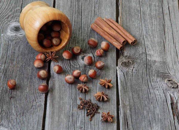 Wood nut, cinnamon sticks, a carnation and anise asterisks on a — Stock Photo, Image