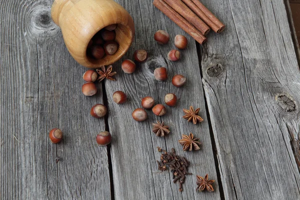 Wood nut, cinnamon sticks, a carnation and anise asterisks on a — Stock Photo, Image