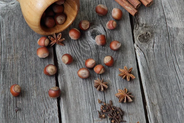 Wood nut, cinnamon sticks, a carnation and anise asterisks on a — Stock Photo, Image