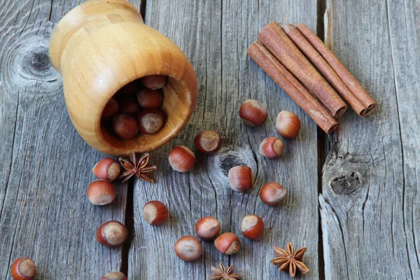 Wood nut, cinnamon sticks, a carnation and anise asterisks on a — Stock Photo, Image