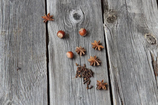 Wood nut, cinnamon sticks, a carnation and anise asterisks on a — Stock Photo, Image